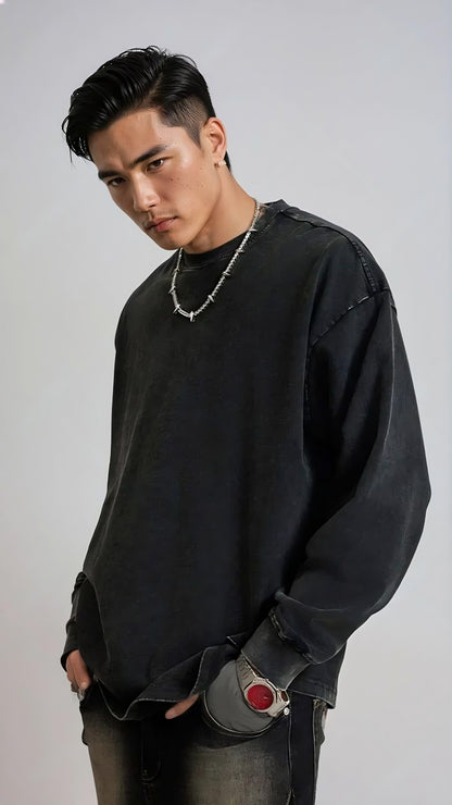 Person wearing a black oversized sweatshirt with a gray background